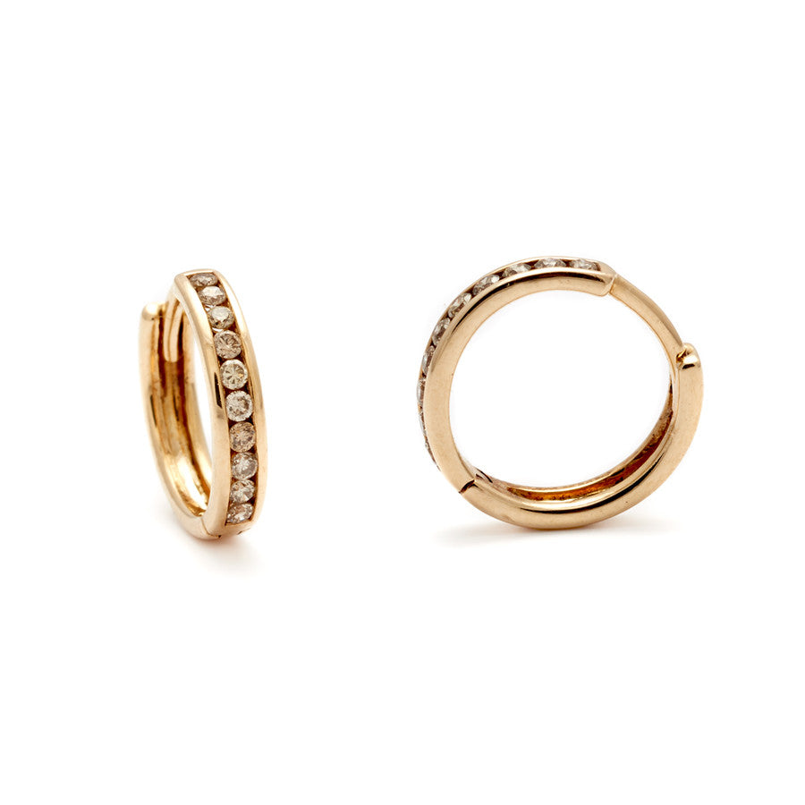 A pair of hoops with a line of champagne diamonds set in yellow gold one earring is angled.