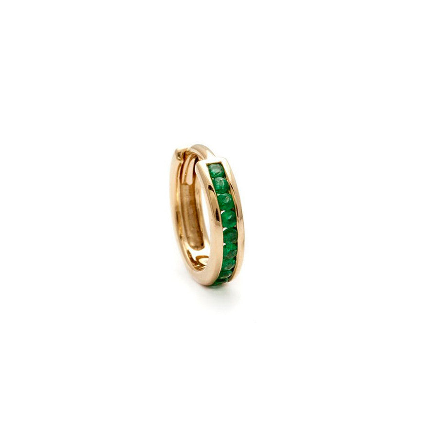 A single hoop with a line of emeralds set in yellow gold.