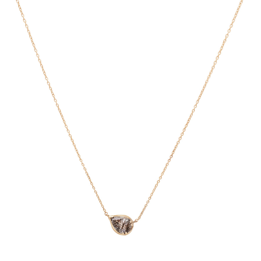 Zoomed out view of a necklace with a pear pendant with a black rutilated quartz set in yellow gold with a yellow gold chain.