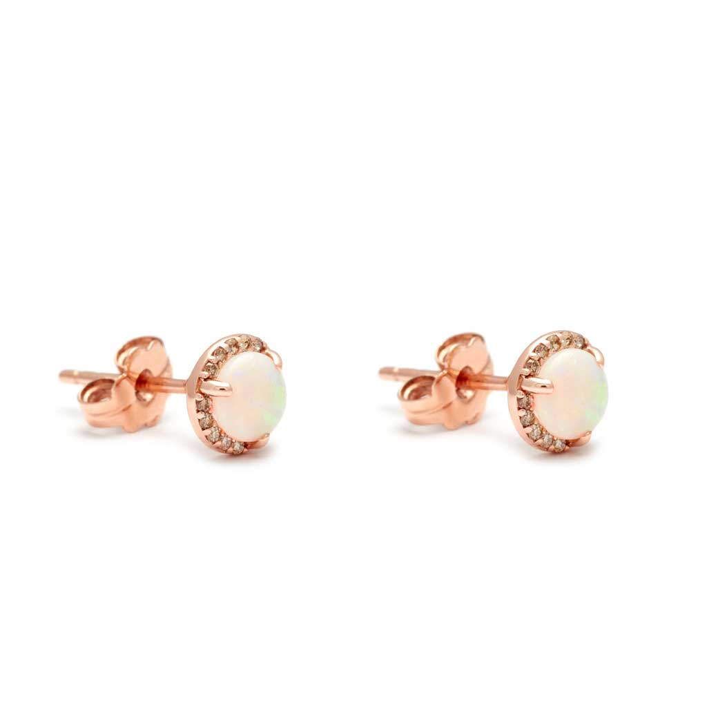 Angled view of a pair of medium opal center stone earrings with a halo of champagne diamond set in rose gold.