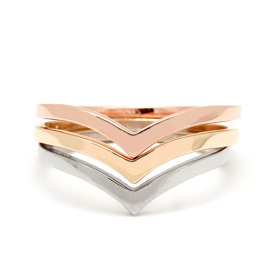 Three solid gold nesting bands in rose, yellow, and white gold.