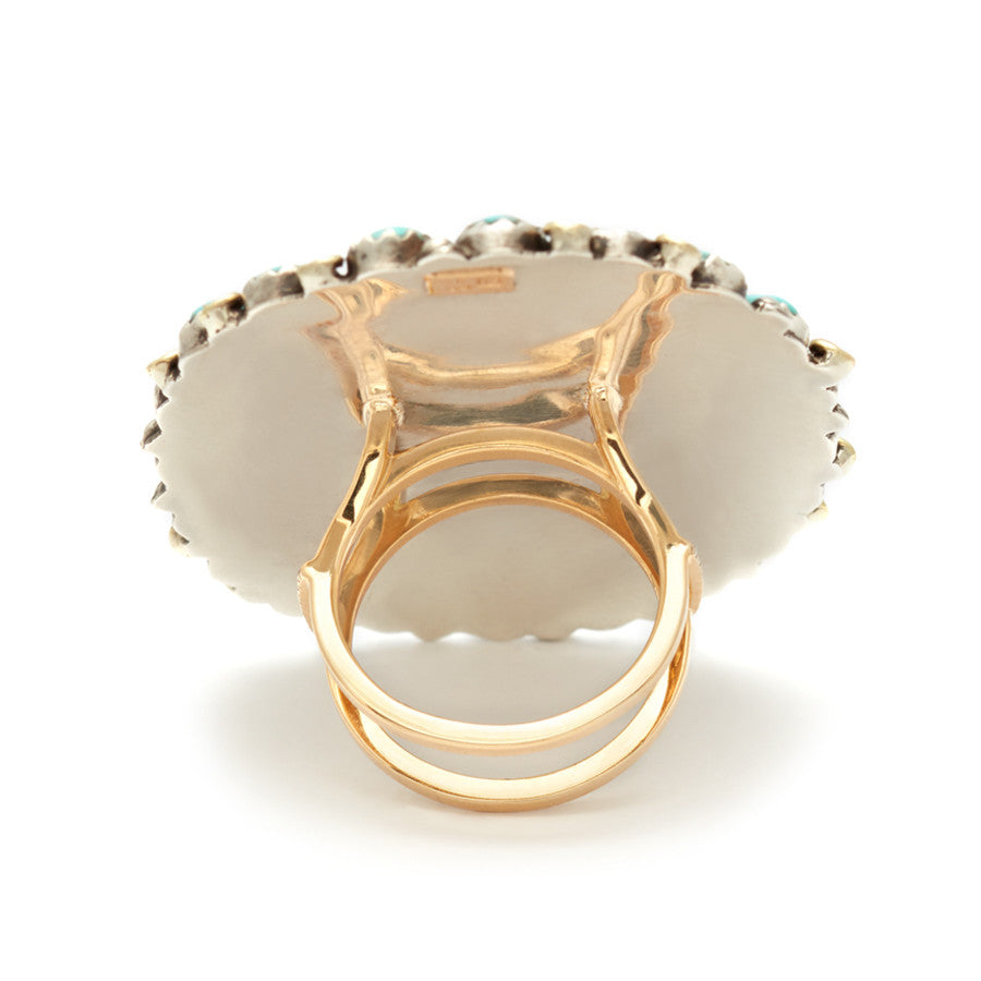 Upside down view of an oval Turquoise concho harness ring set in yellow gold.