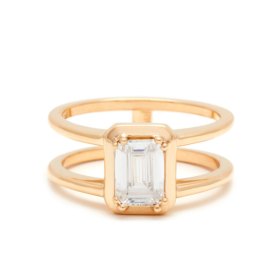 A double banded engagement ring with a white diamond emerald cut diamond set in yellow gold.