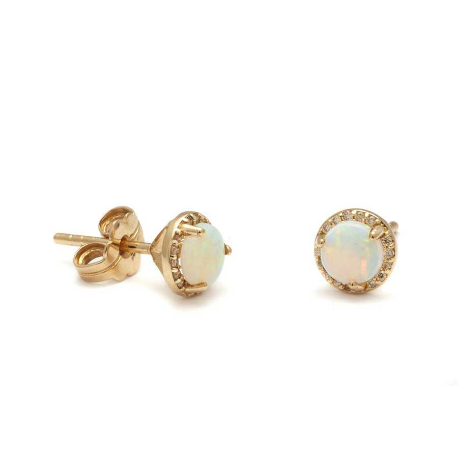 A pair of medium opal center stone earrings with a halo of champagne diamond set in yellow gold one earring angled.