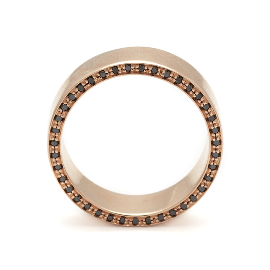 Side view of a 7mm flat band with black diamond accents around the band set in rose gold.